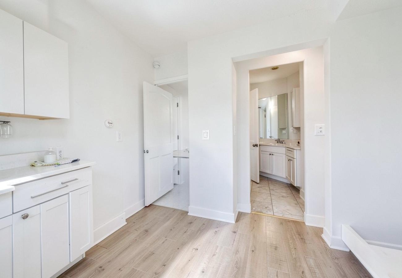 Empty home interior showing kitchen, hallway and bathroom areas