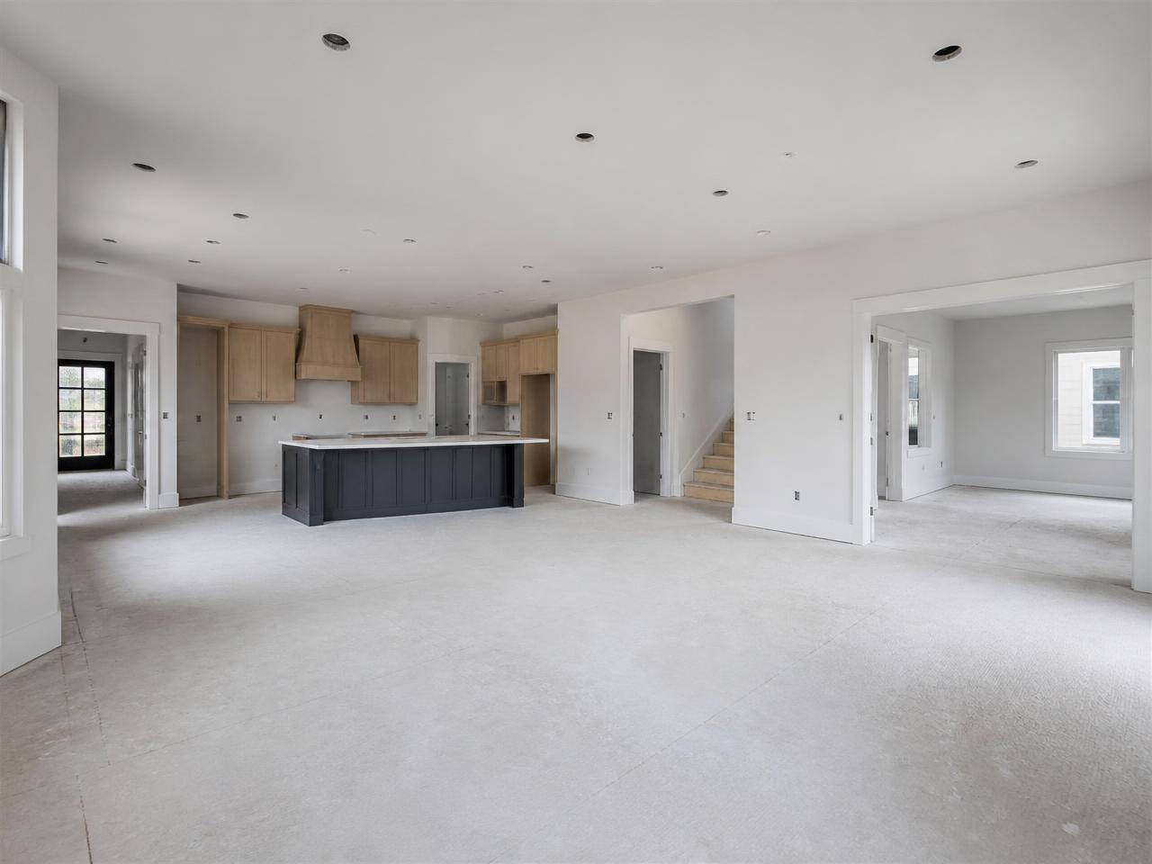 Large newly built open-plan home interior with multiple connected rooms before final cleaning